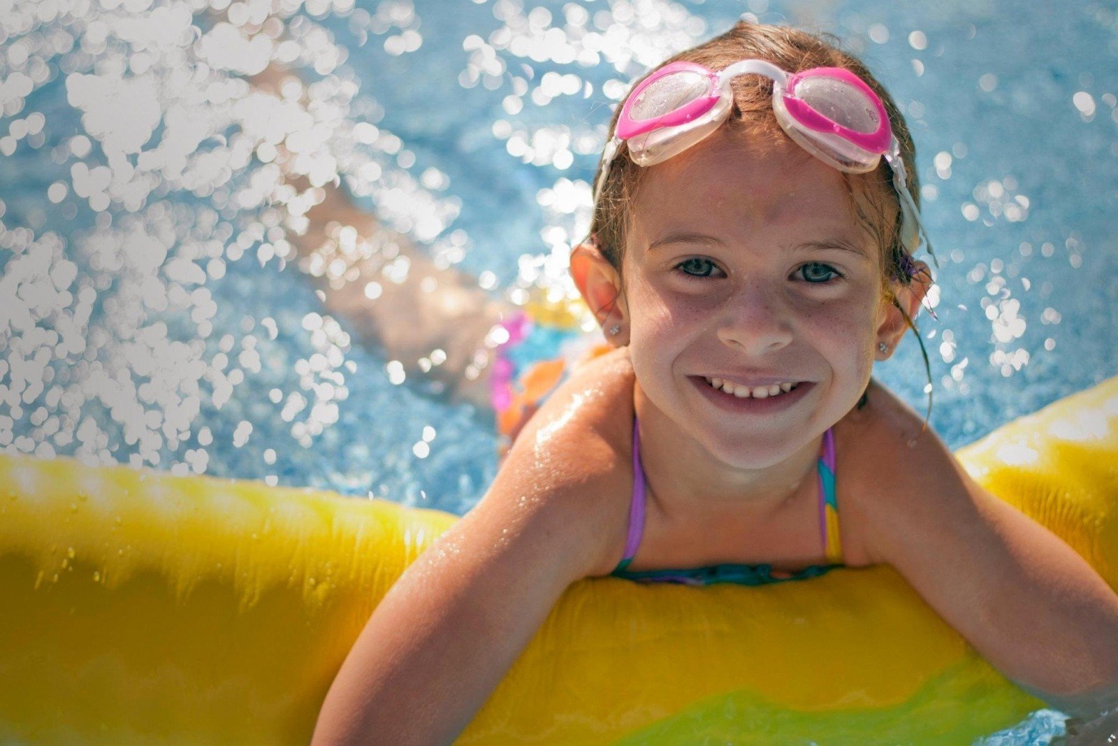 girl smiling in swimming pool - justifying using the benefits of swimming