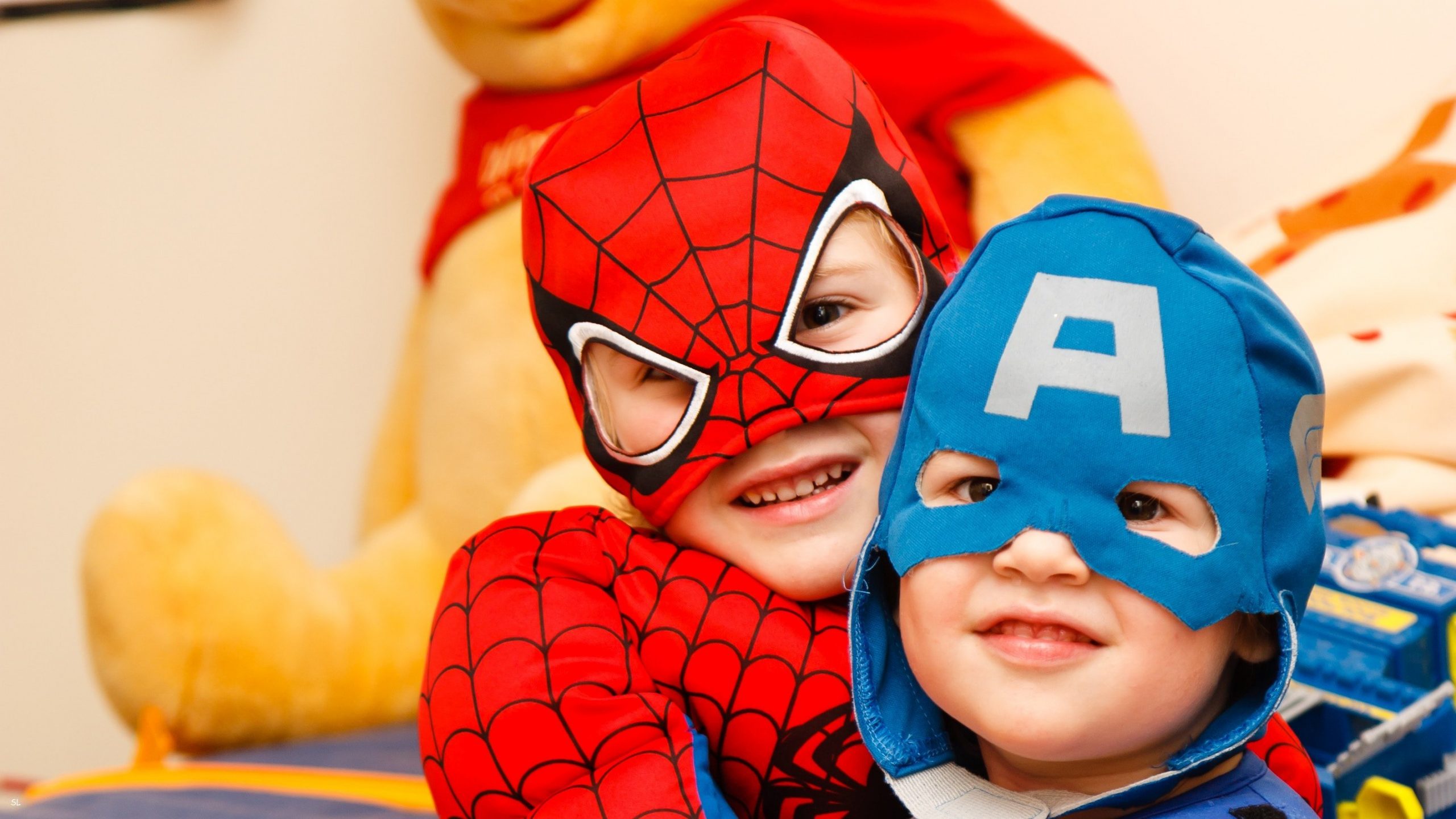 two kids in spiderman and captain america costume smiling